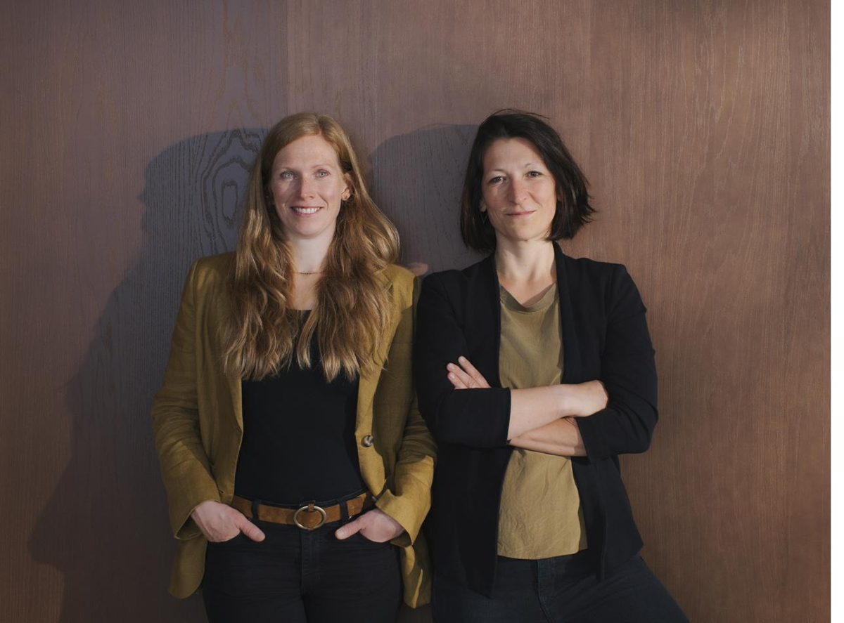 Stefanie Bayer und Julia Menzler vor einer Holzwand